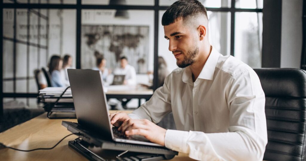 alt="Jak wybrać program do KSeF – przedsiębiorca pracujący przy laptopie w biurze"